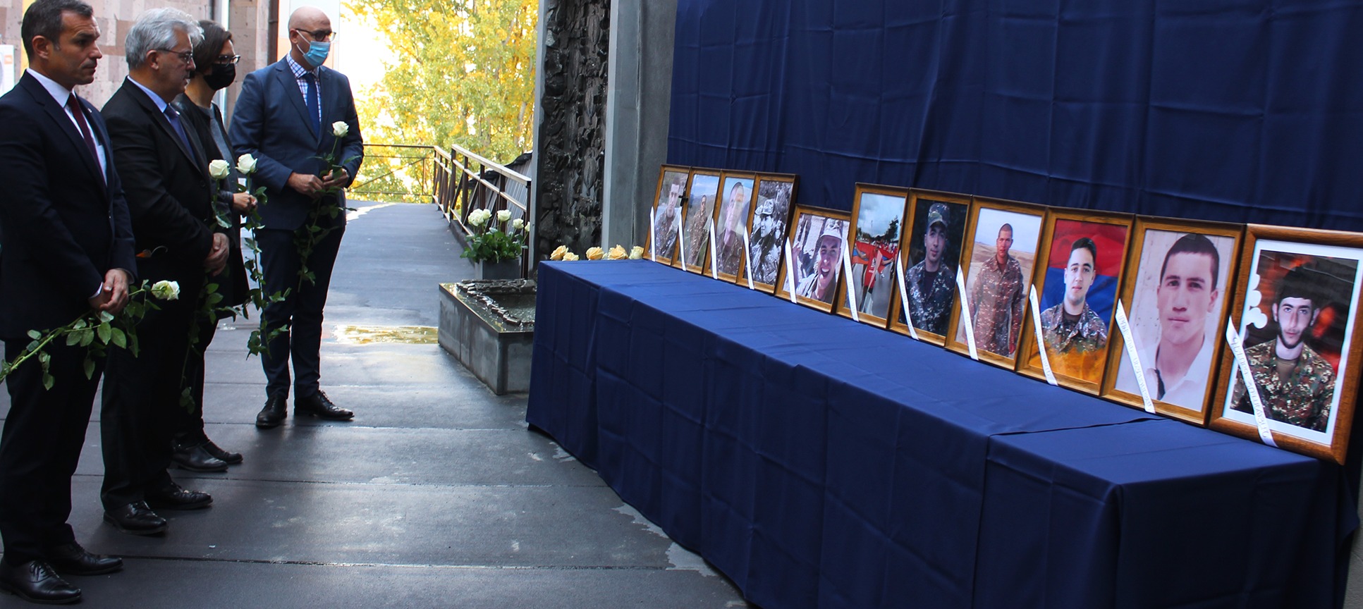 La délégation à l'UFAR, devant les portraits des étudiants de l'UFAR tombés lors de la derrière guerre.